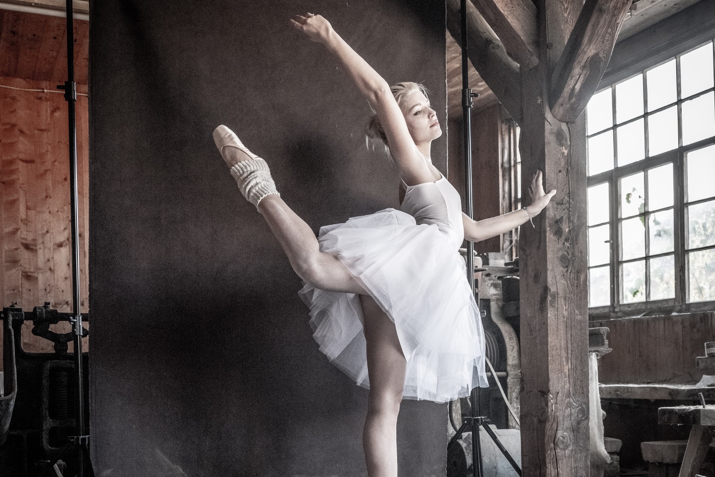 Frau im Ballett Outfit posiert in einer alten Fasswerkstatt