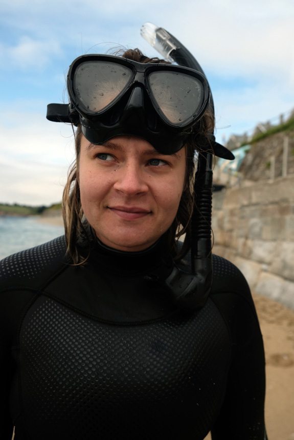 Close-portrait of woman on beach wearing wetsuit, diving mask and snorkel