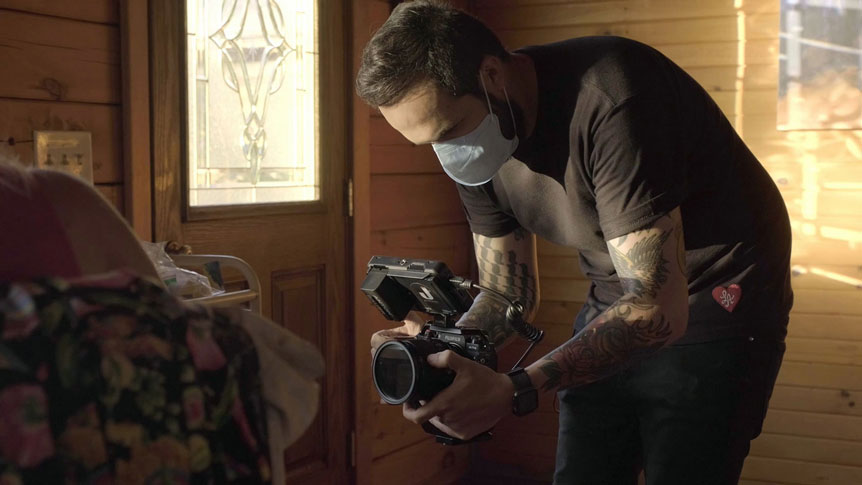Videographer, Giulio Meliani uses FUJINON XF50mmF1.0 R WR to profile legally-blind artist, Therese Verner and show the importance of art. Image shows a behind-the-scenes photograph of Giulio Meliani filming handheld with a facemask on due to the Covid-19 pandemic.