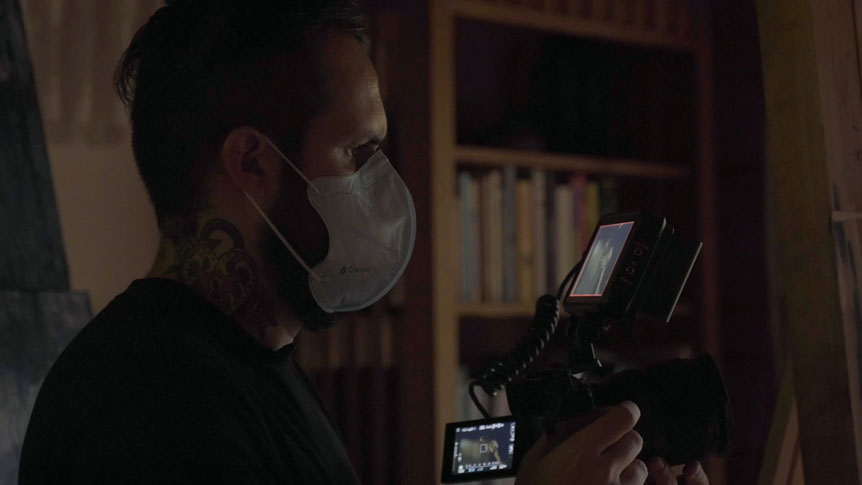 Videographer, Giulio Meliani uses FUJINON XF50mmF1.0 R WR to profile legally-blind artist, Therese Verner and show the importance of art. Image shows a profile photograph of Giulio Meliani filming handheld wearing a facemask due to the Covid-19 pandemic.