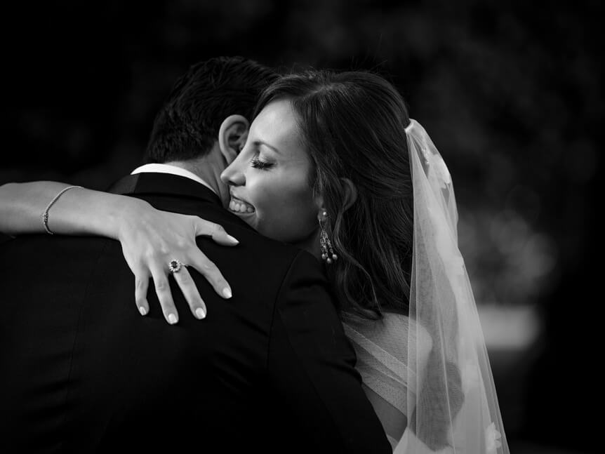 Professional photographer, Alison Conklin, on why the FUJIFILM GFX system is so good for location portrait photography. Image shows black and white photo of bride hugging groom on wedding day.