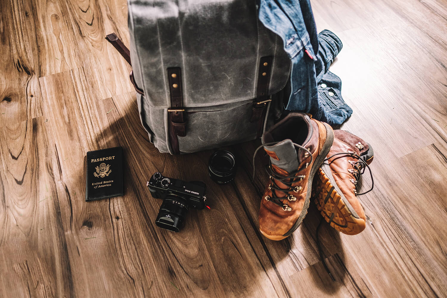 FUJIFILM Exposure Center. Image of packed bag, denim jacket, walking boots and passport on wooden floor.