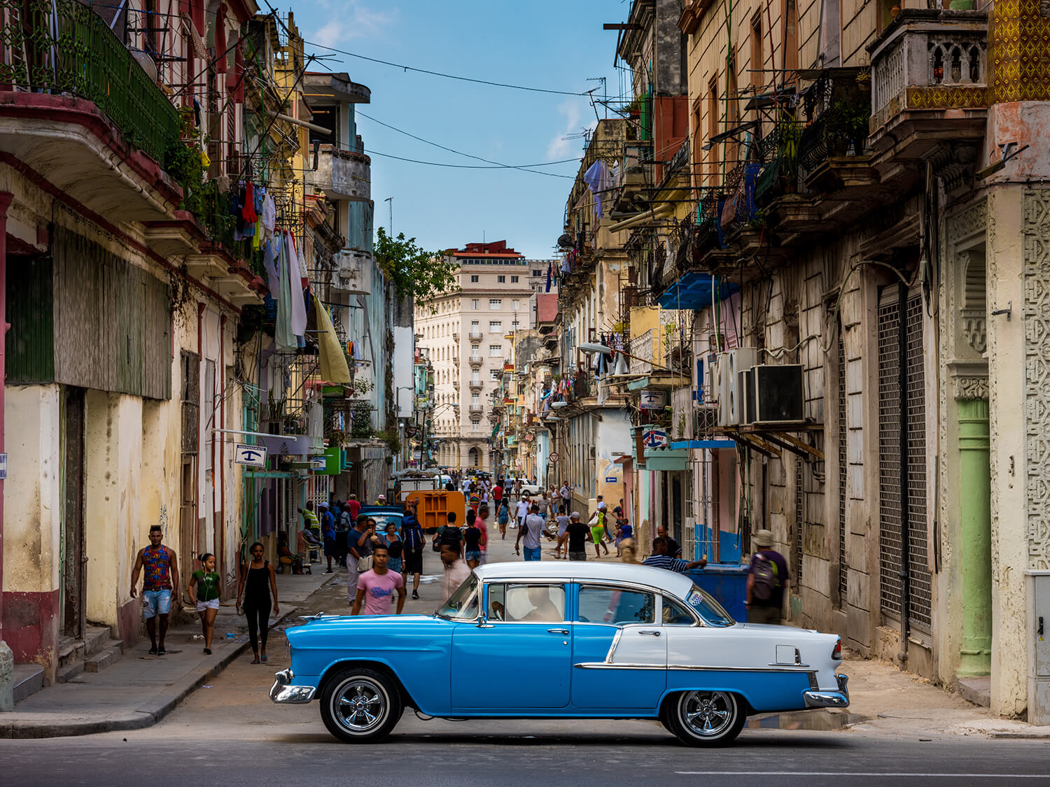 FUJIFILM Exposure Center. Shot down a busy Cuban street with blue vintage American car in foreground.