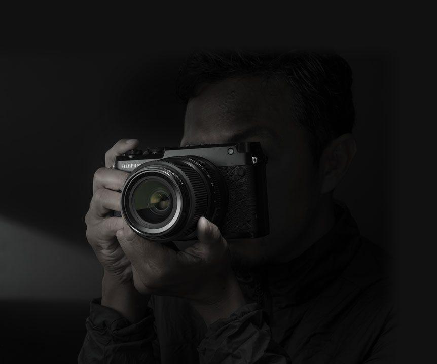 FUJIFILM GFX50R camera being hand held up to a photographer's eye