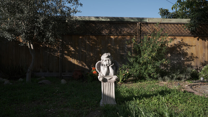 A wide-angle frame of a cherub statue in a garden