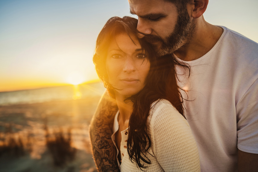 A young man and woman holding each other in sunset light