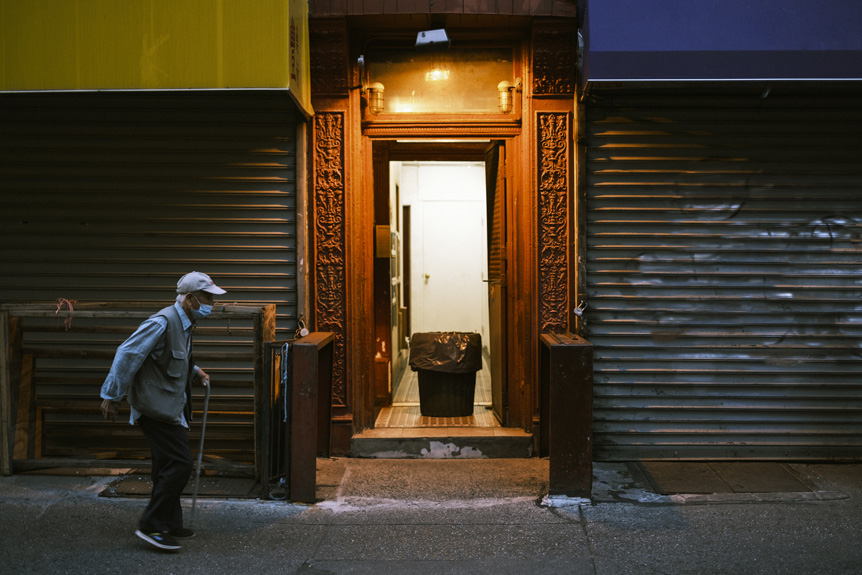 Man walking past lit doorway