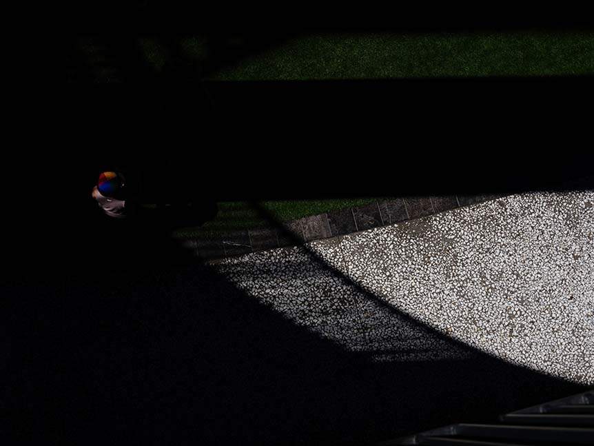 Top-down view of someone standing on street in dark shadow