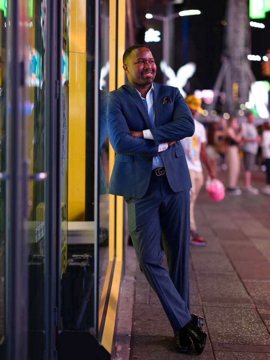 Man in blue suit posing on New York street at night