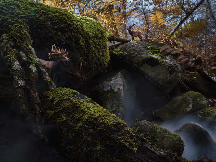 Figurines of two stags by miniature waterfall