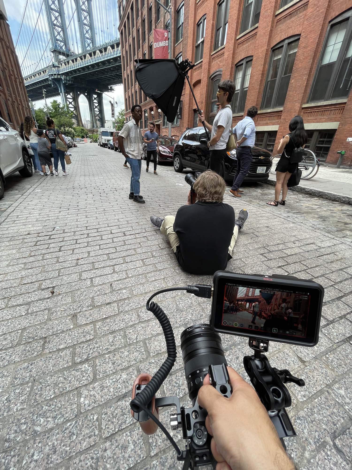 Man filming a photographer conducting portrait session on the street