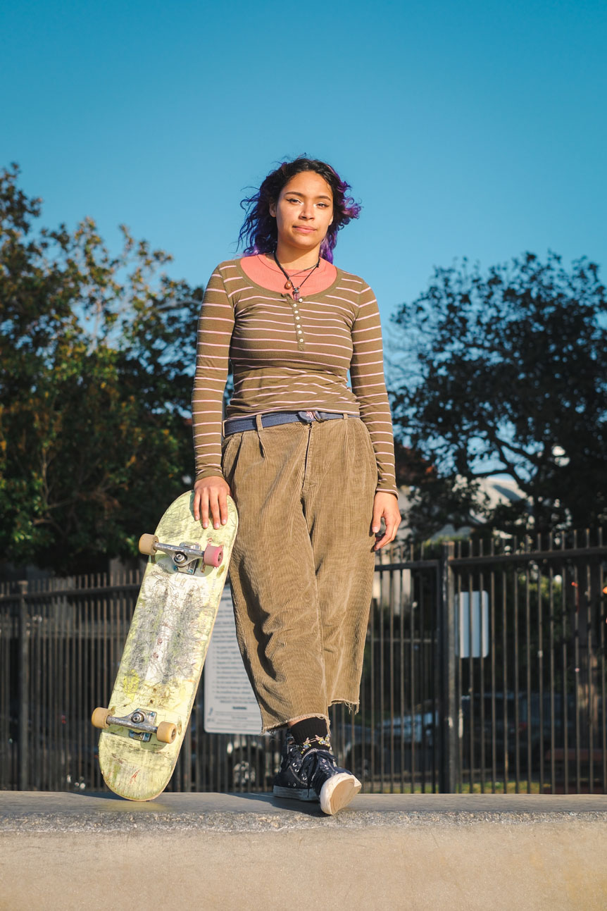Young woman standing with skateboard