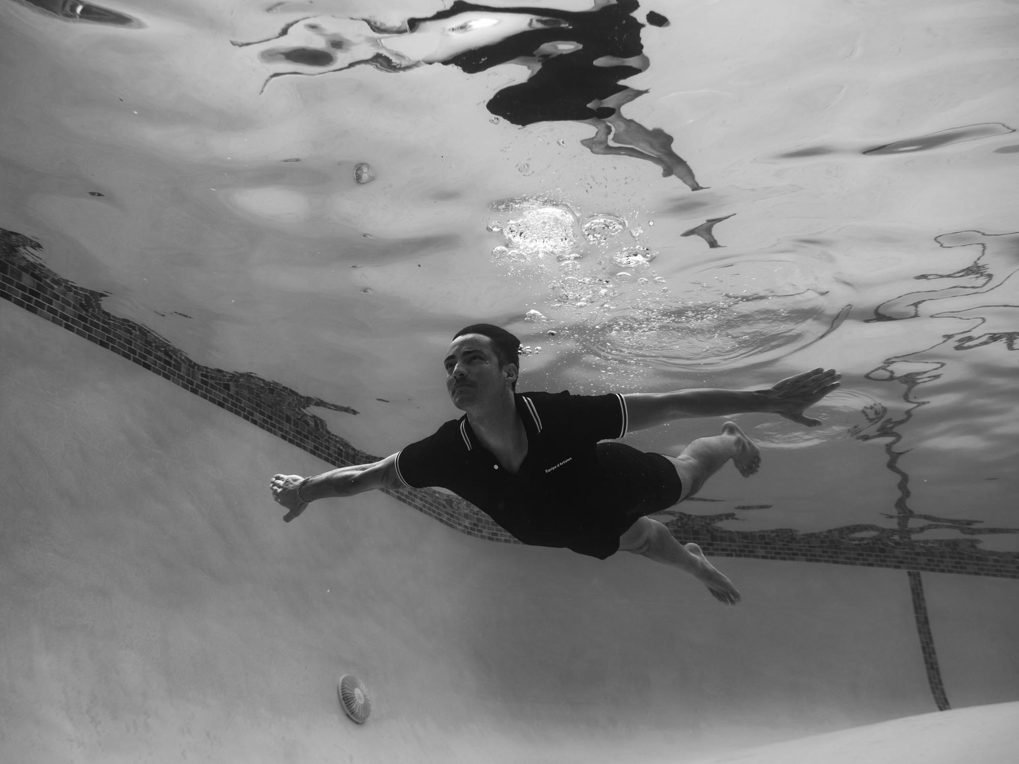A black and white image of a man swimming underwater