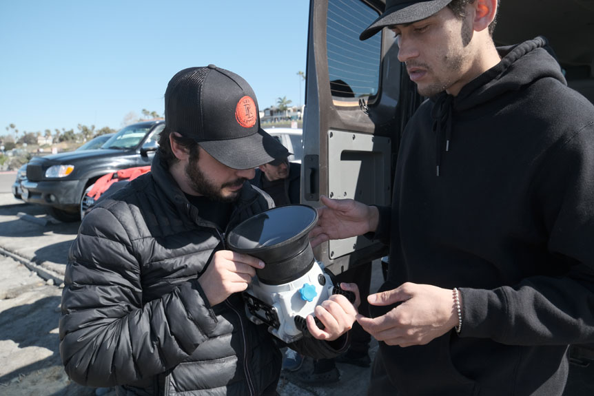 Two filmmakers inspecting camera in waterproof housing