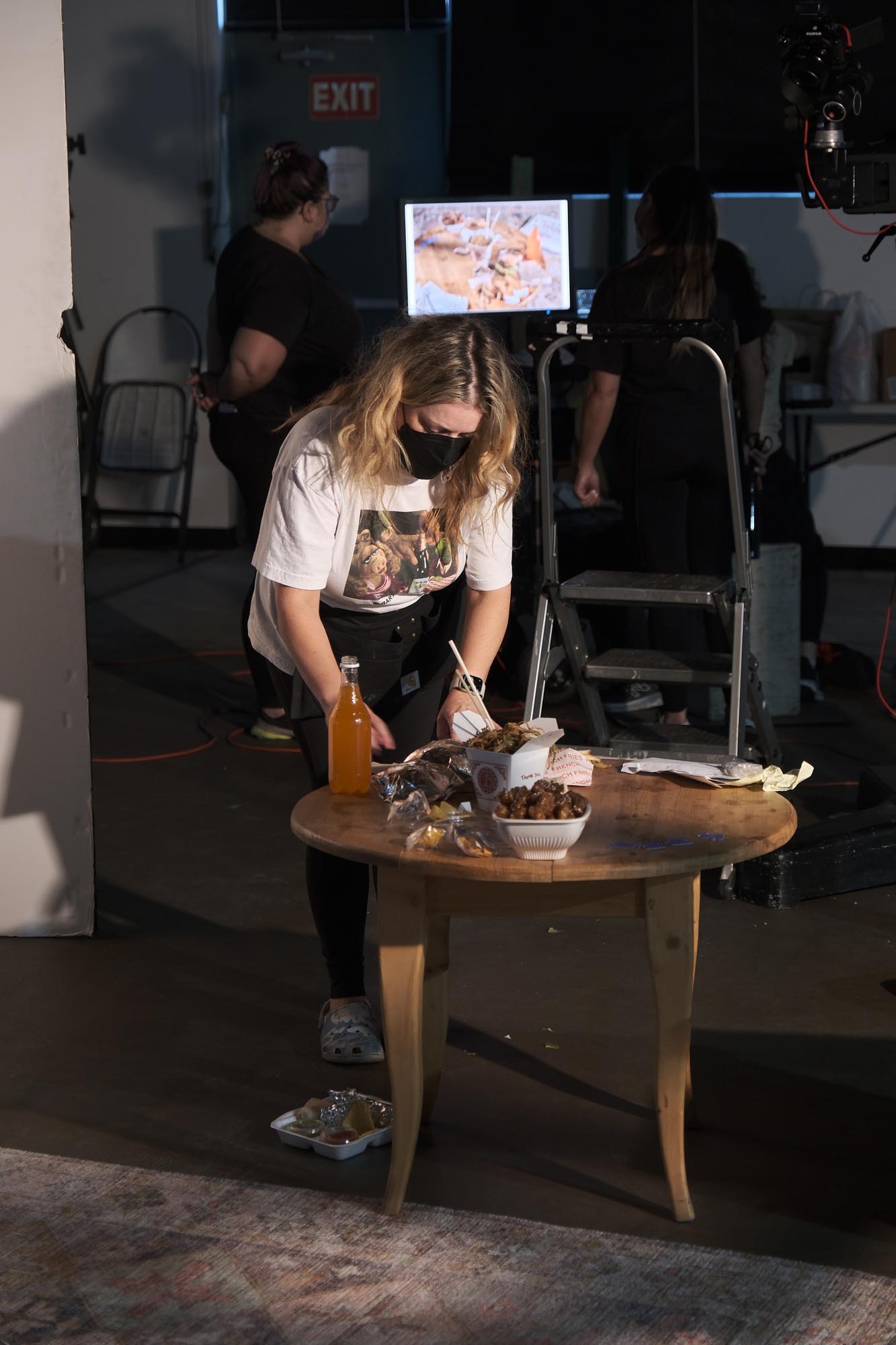 A woman prepares a table of food for a shot on a commercial shoot