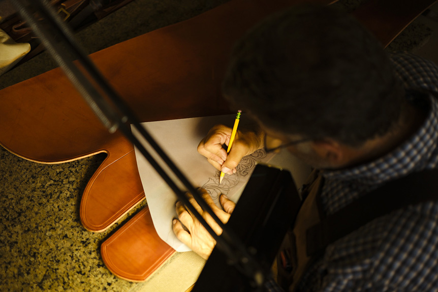 Man tracing pattern onto leather