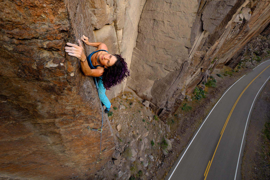 Woman climbing rock face