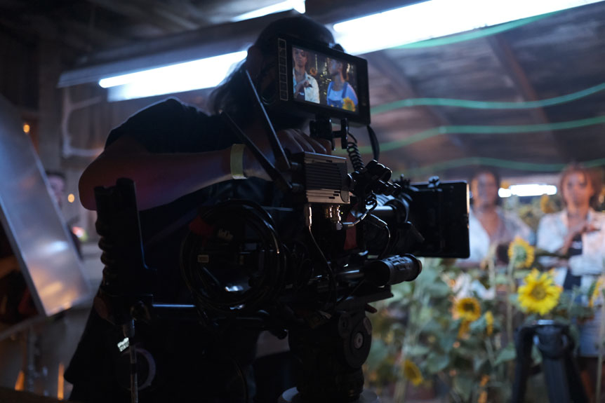 Cinema camera and crew inside barn