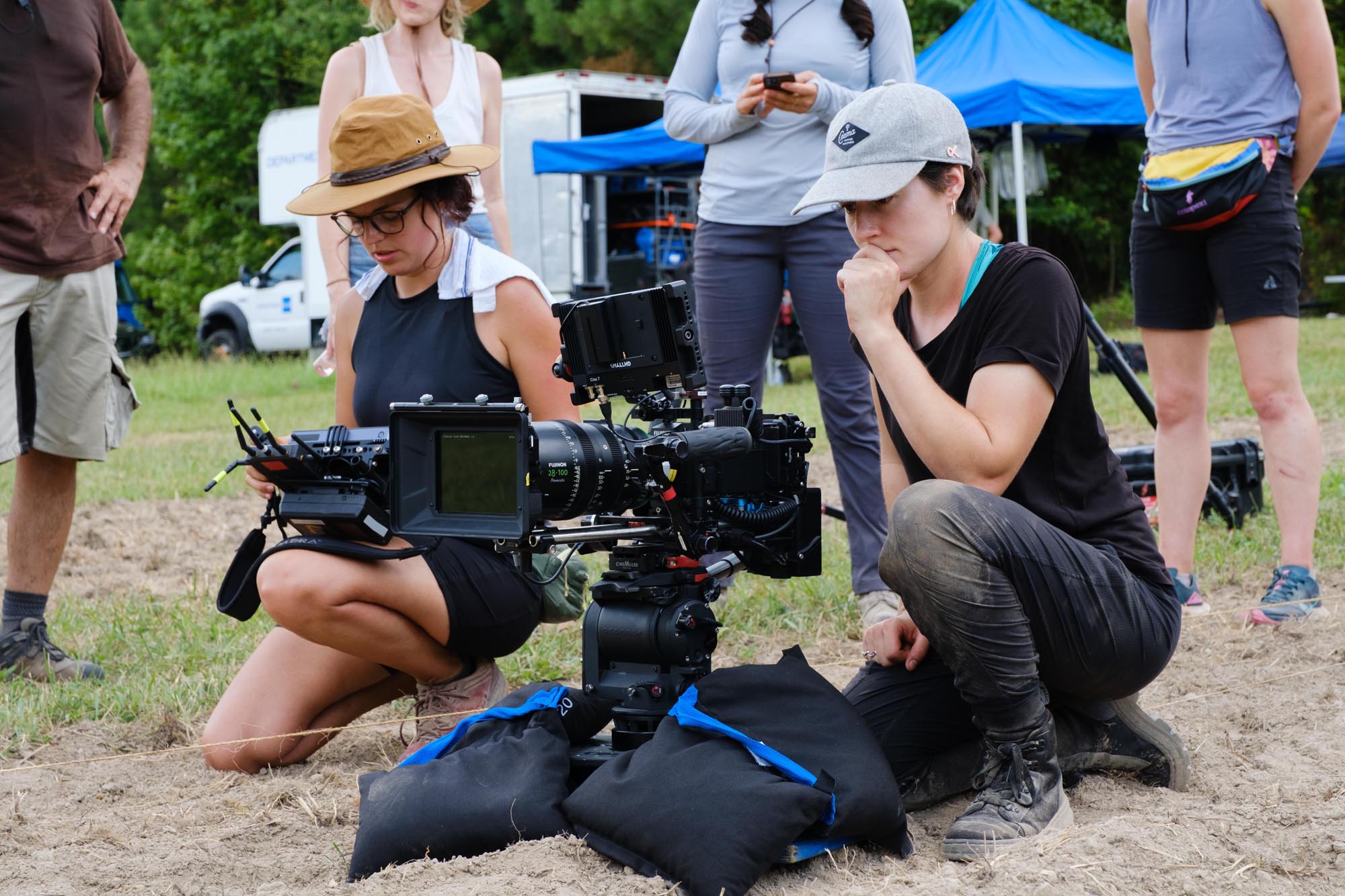 A female director and DP set up a shot in a grassy field