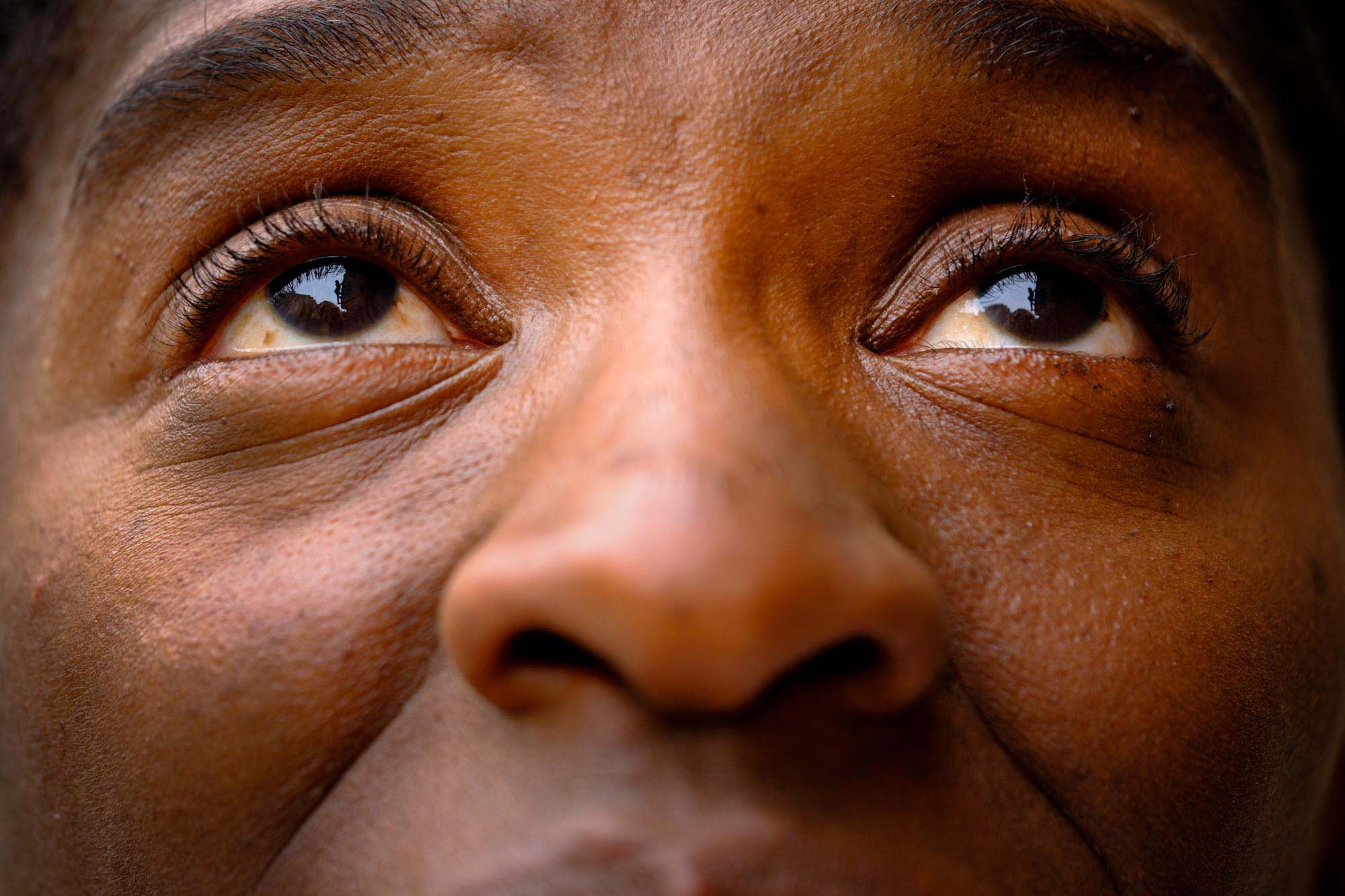 A fragmented extreme close-up of a woman's misty-eyed gaze