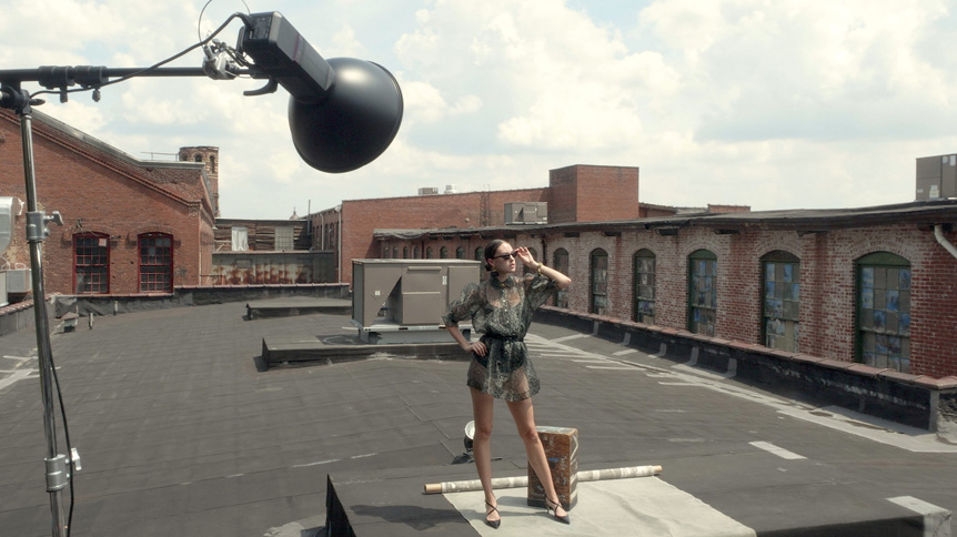 Young woman fashion model posing on building rooftop