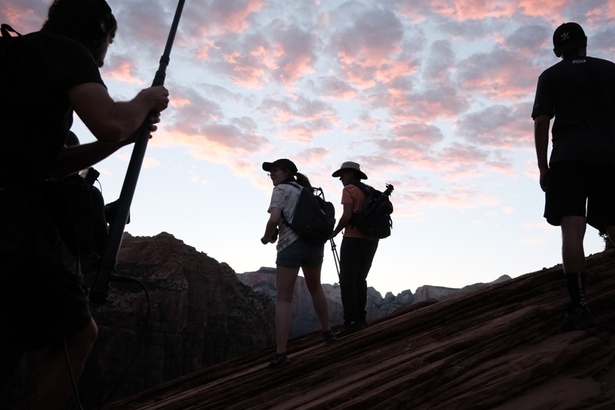 Silhouette of two women on mountainside under dusky sky