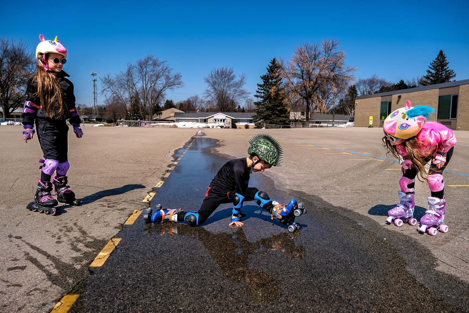 Boy in roller-skates does splits across a puddle