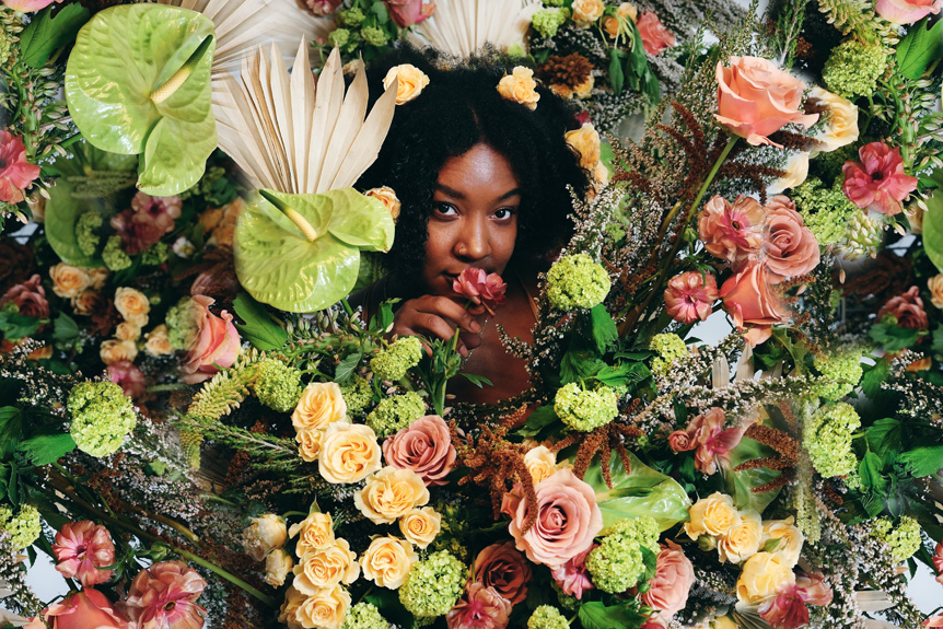 Girl's face among yellow, pink and green flowers