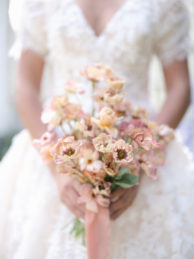 Close up image of wedding flowers in photos with blurred bride in the back