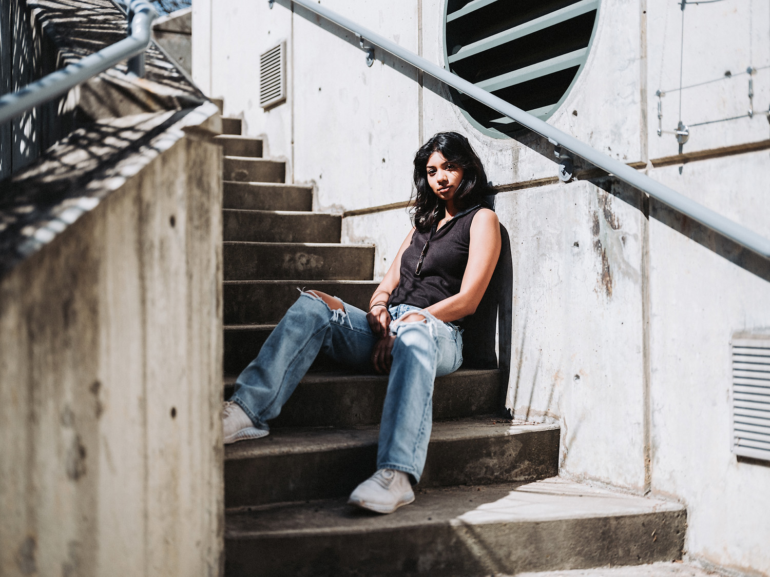 Woman sat outside on stairs looking at camera