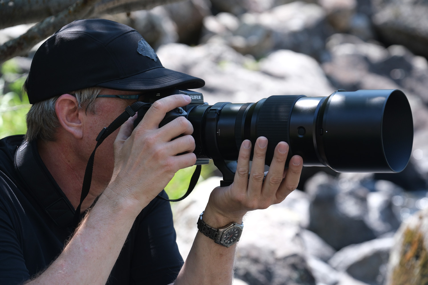 Sports photographer using telephoto lens to capture kayaking