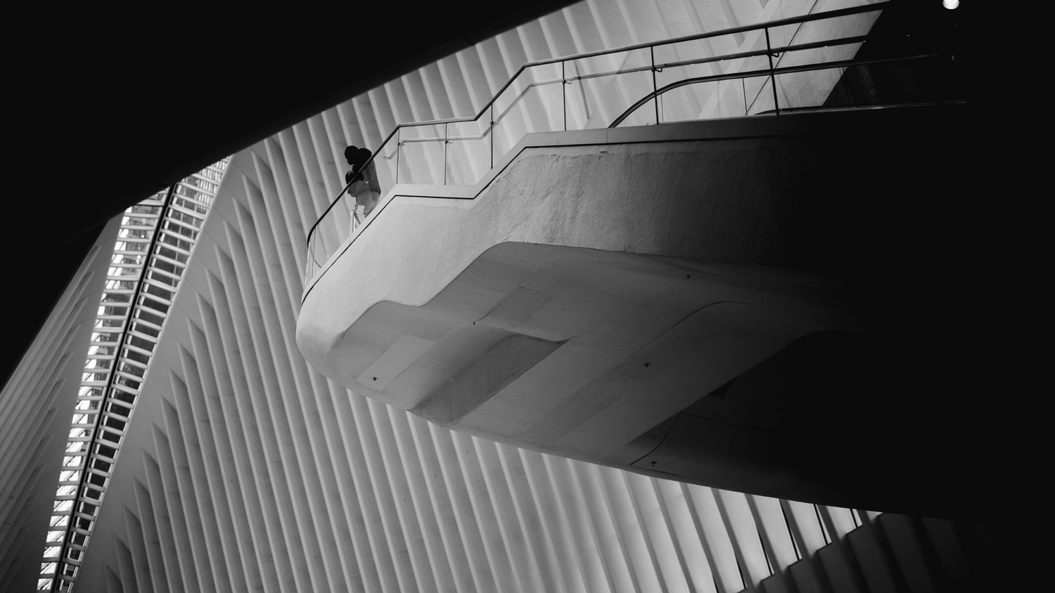Abstract black and white image of a person standing on balcony